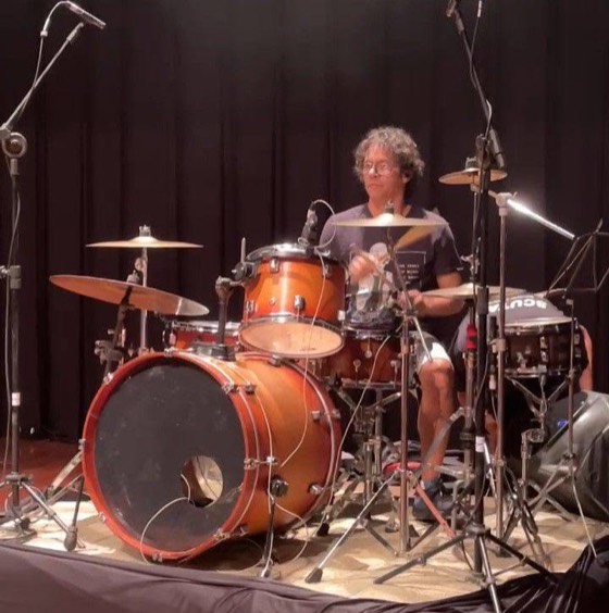 Claudinho Mendonça tocando bateria no palco